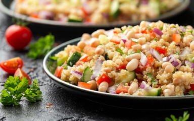 Quinoa white bean salad with cherry tomatoes, cucumber, red onion and herbs. Healthy vegan food