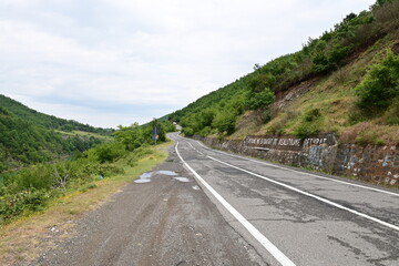 Straße an der Brücke Ura e Ulzes in Albanien, mit Bäumen und Bergen