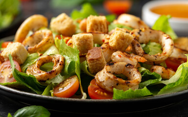 Grilled squid or calamari and shrimp salad with garlic croutons and cherry tomatoes. healthy food.