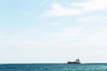 Ship on the crisp blue water with lots of sky and room for text.