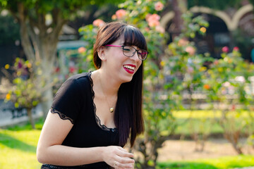 Fototapeta premium portrait of a woman with glasses smiling and laughing at the park