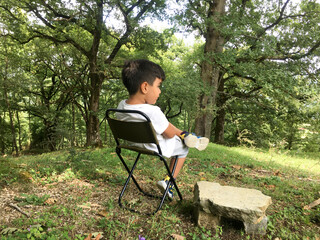 Fototapeta premium Little boy resting outdoors.