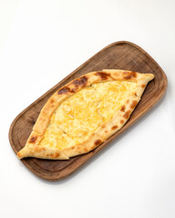 Open pie or pizza with cheese filling on wooden cutting board isolated on white background. Top view.