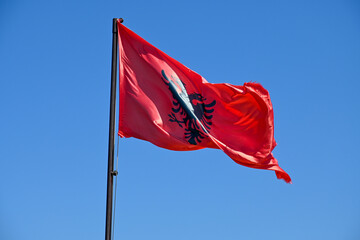 Flagge Albanien weht im Wind mit blauem Himmel