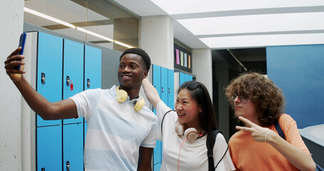 Three multi-ethnic teenage students take a selfie at school. High school