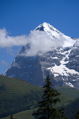 Mountain peak Eiger at Bernese highland on a sunny summer day with blue sky background and clouds...