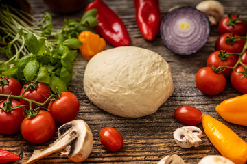 Raw delicious pizza dough with many vegetables served on black