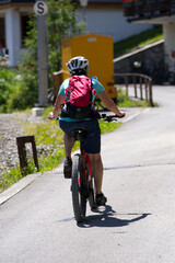 Middle aged woman on mountain bike in the Swiss alps on a beautiful summer day. Photo taken July 20th, 2021, Lauterbrunnen, Switzerland.