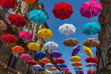Fototapeta na wymiar Brive la Gaillarde (Corrèze, France) - Décorations de rue estivale avec des parapluies colorés