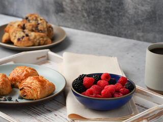 Breakfast tray with croissants against light colored background