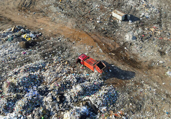 Arial view of garbage truck during unloading the rubbish and food waste. Recycling garbage. Work at landfill. Waste conservation. Trash disposal on rubbish dump. Soft focus