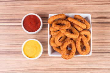 portion of onion rings on wooden background