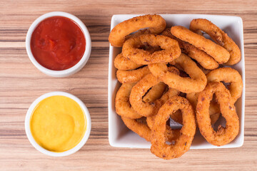 portion of onion rings on wooden background
