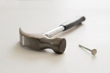 Closeup of a hammer and nail on white background
