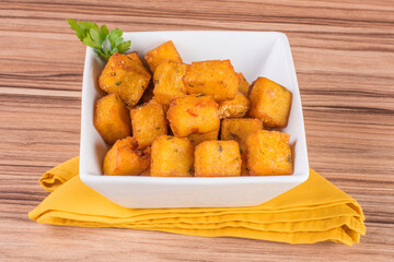 portion of fried polenta on wooden background
