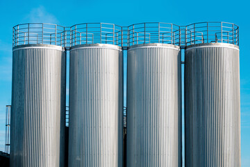 metal industrial silo towers for bulk and liquid materials against the sky