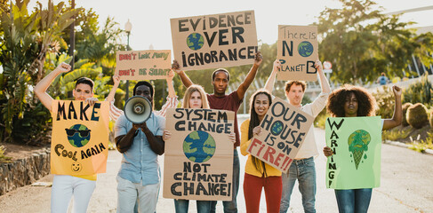 Young people fighting for climate while holding banners outdoors in the street - Focus on front faces - obrazy, fototapety, plakaty