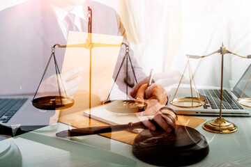 Business and lawyers discussing contract papers with brass scale on desk in office. Law, legal services, advice, justice and law concept picture with film grain effect