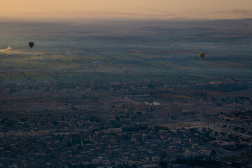 Sunrise hot air balloon flight in Luxor, Egypt. The Nile and Luxor temple are covered in the thick morning fog.