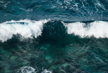 Blue-green waves on the surface of the ocean. Top view of the water.