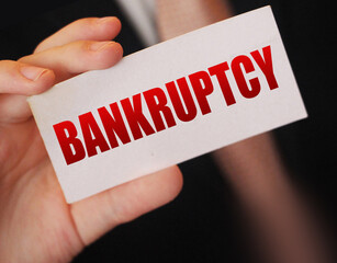 Bankruptcy on a card. Businessman holding a card with word Bankruptcy. Crisis business closing...
