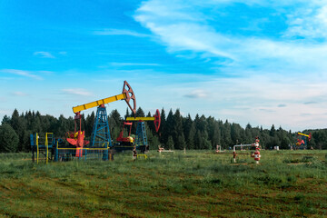Fototapeta na wymiar oil pumping stations in a clearing in the forest