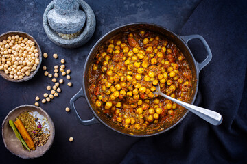 Traditional Indian chana masala curry stew with chickpeas and spices served as top view in saucepan - obrazy, fototapety, plakaty