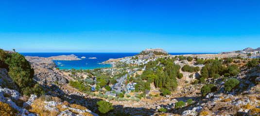 Lindos, with its ancient acropolis, ruins fortress and closed bays in sea coast, is the most view...