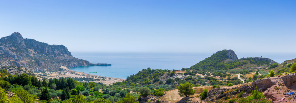 Tsambika Beach in a closed bay. Famous place for beach leisure and multifarious water attraction. Vacation on Greece islands in Aegean and Mediterranean sea. Kolympia. East Rhodes. Greece