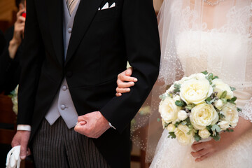 Where the bride and dad are holding their arms at a wedding