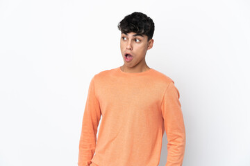Fototapeta premium Young man over isolated white background doing surprise gesture while looking to the side