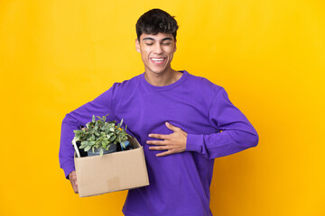 Man making a move while picking up a box full of things smiling a lot