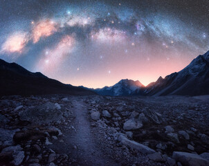 Arched Milky Way and mountains at night. Beautiful landscape with bright milky way arch, rocky...