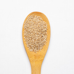 Sesame seeds in a  spoon on  white background