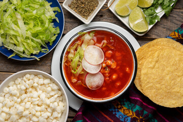 Mexican food. Red pozole with chicken on wooden background