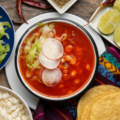 Mexican food. Red pozole with chicken on wooden background