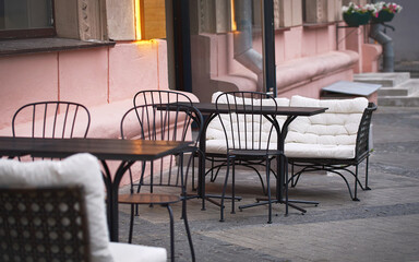 Empty chairs and tables in restaurant during pandemic. Summer terrace restaurant in city center. Summer outdoor cafe. Tables and chairs, summer cafe