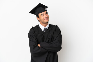 Young university graduate over isolated white background looking up while smiling