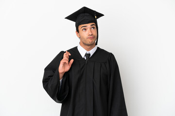 Young university graduate over isolated white background with fingers crossing and wishing the best