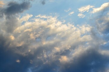 Obraz premium Cirdle gray-white clouds in the rays of sunset .