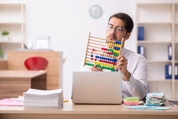 Young male bookkeeper in budget planning concept holding abacus