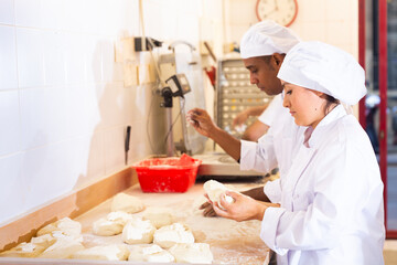 Male and female baker working together in bakery shop