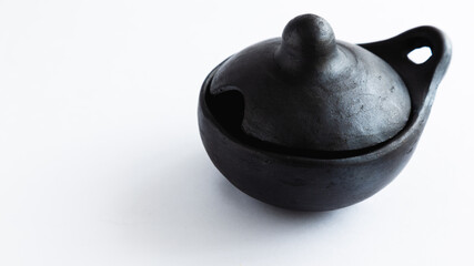 Naklejka na ściany i meble black clay dish, a traditional Colombian dish for serving chili peppers, White background