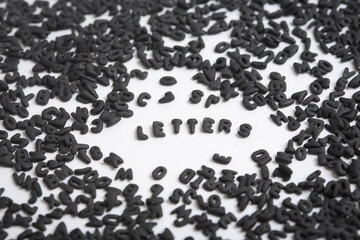 Photo of small black letters on white background. Photo of single letters forming the word letters in the middle. Black letters forming the word letters