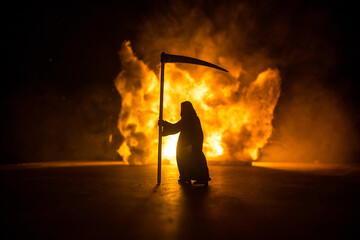 Scary view of grim reaper at cemetery with spooky cloudy sky and fog, Horror Halloween concept....