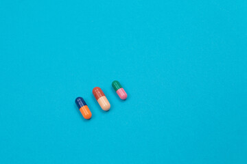 Global Pharmaceutical Industry and Medicinal Products - Colored Pills or Capsules Scattered on Blue Background