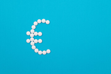 Global Pharmaceutical Industry and Medicine Business - Euro Symbol Made from White Pills Lying on Blue Background