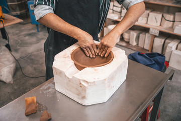 young adult potter molding with clay to make a piece of ceramic