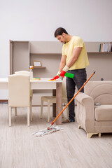 Young male contractor cleaning the house