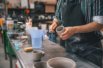 young adult potter preparing some pieces of clay to put in the kiln